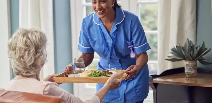 female-care-worker-uniform-bringing-meal-tray-senior-woman-sitting-lounge-home-scaled-q0n6u8w2o5q5mccq8xp2pw96aoxc5p3mpmyugkqs2o
